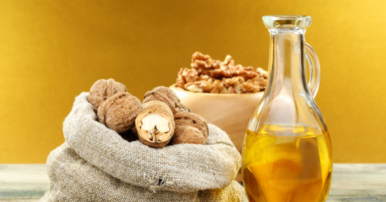 Walnut oil beside raw walnuts.