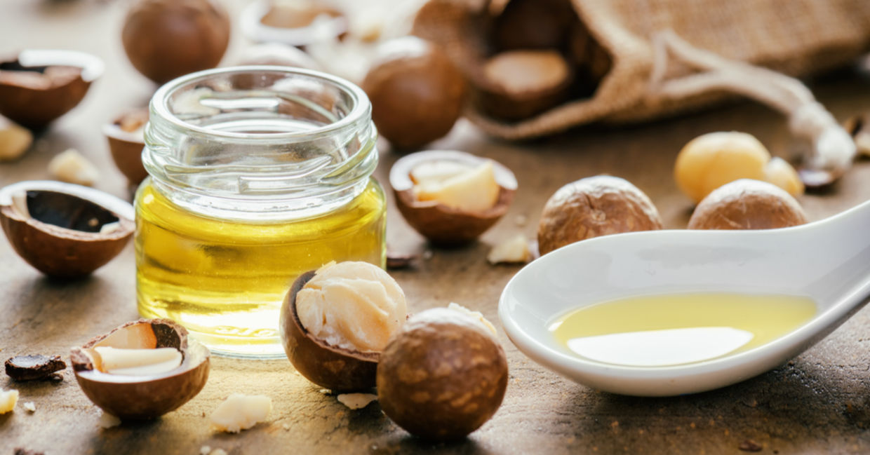 Macadamia nuts beside a bottle of healthy macadamia oil.