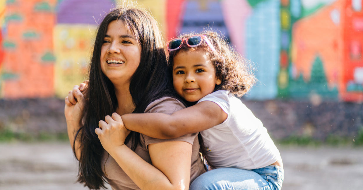 A mother carries her daughter.