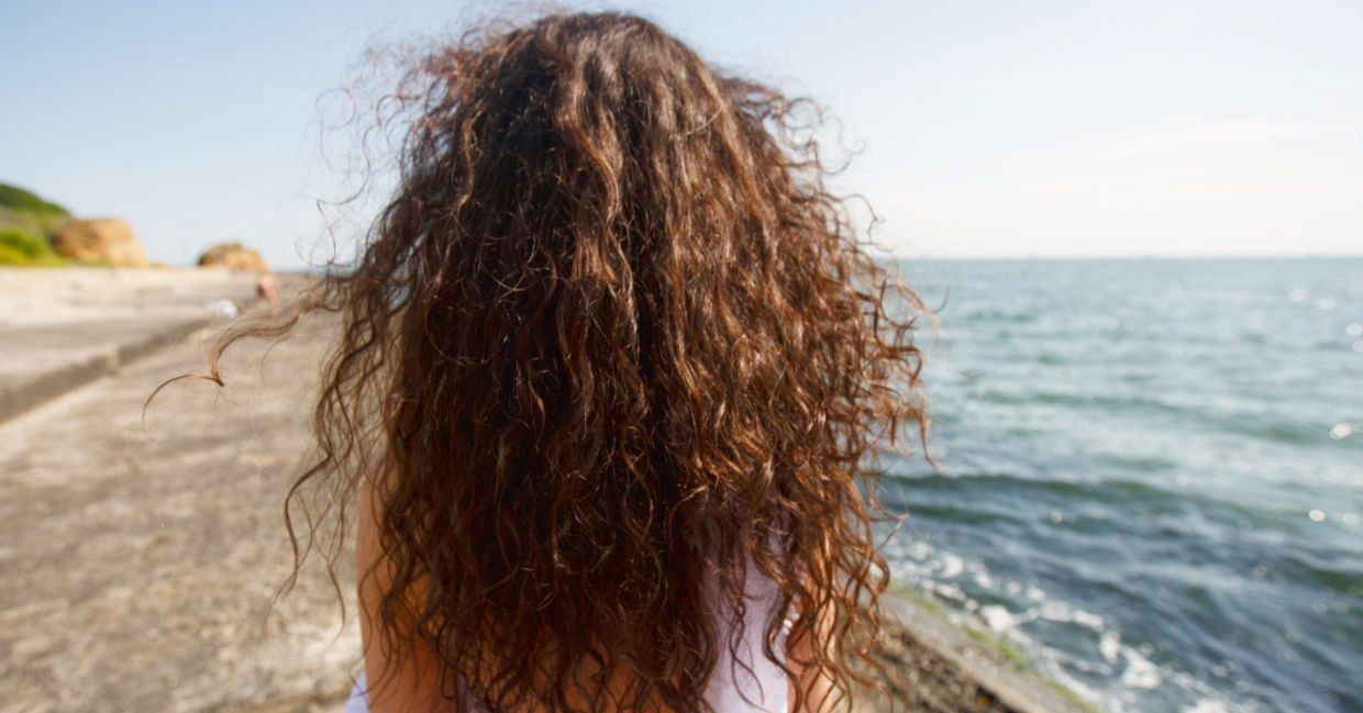 Young woman with long hair at the beach.
