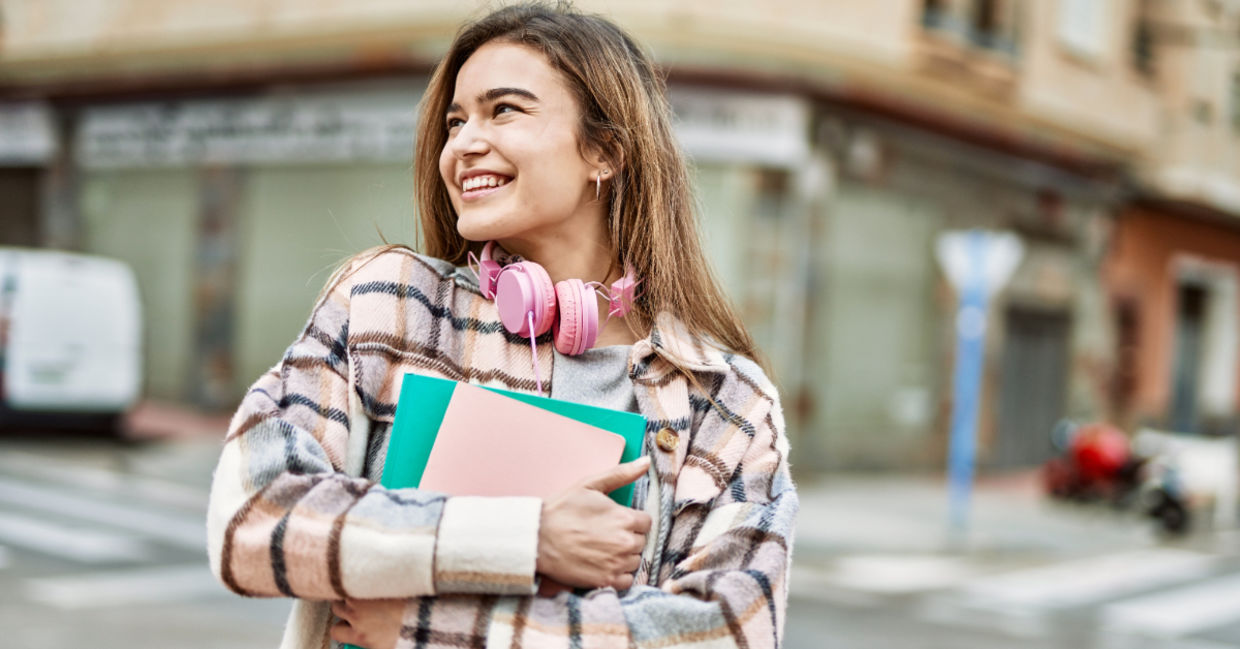 A young woman holding books.