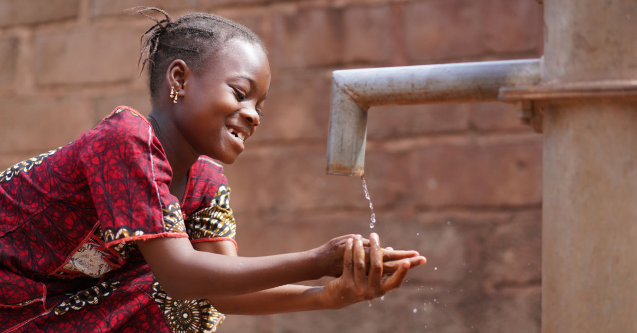 An African boy washing his hands.
