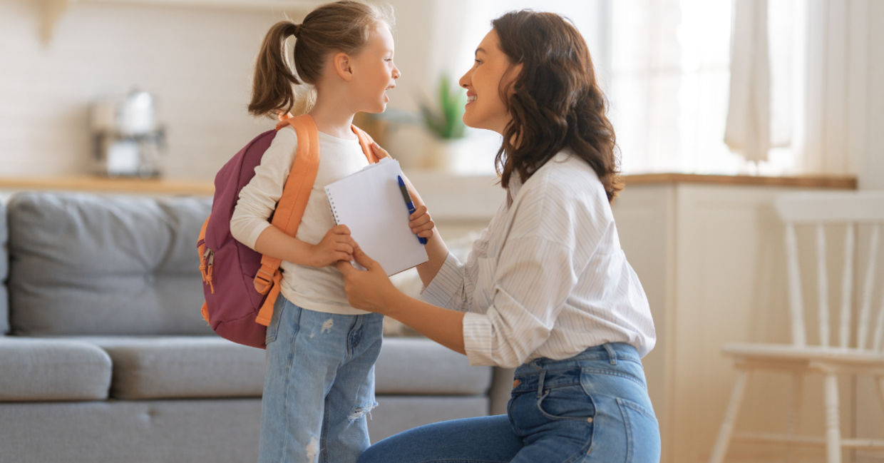 Mother and daughter with backpack and notebook