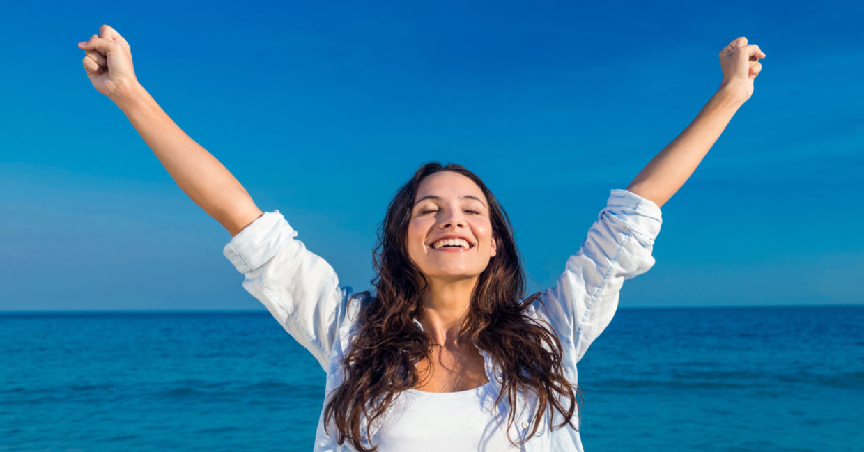 Happy woman by the beach.