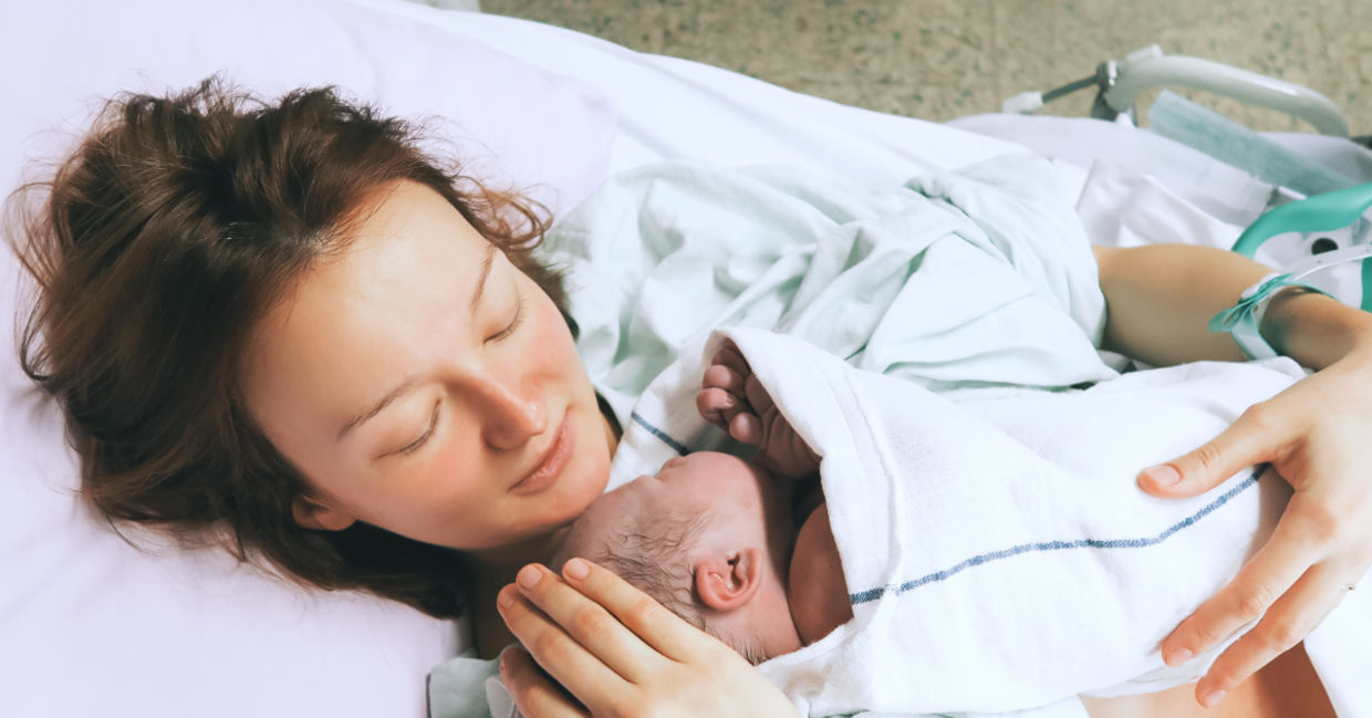 Mother cuddling her newborn baby.