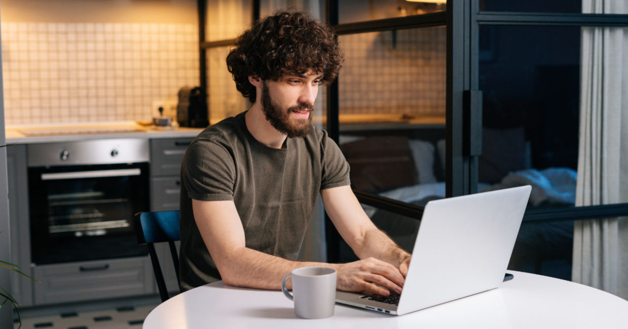 A young man typing on a laptop.