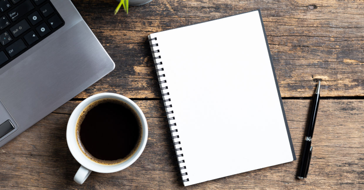 An empty notebook and a computer.