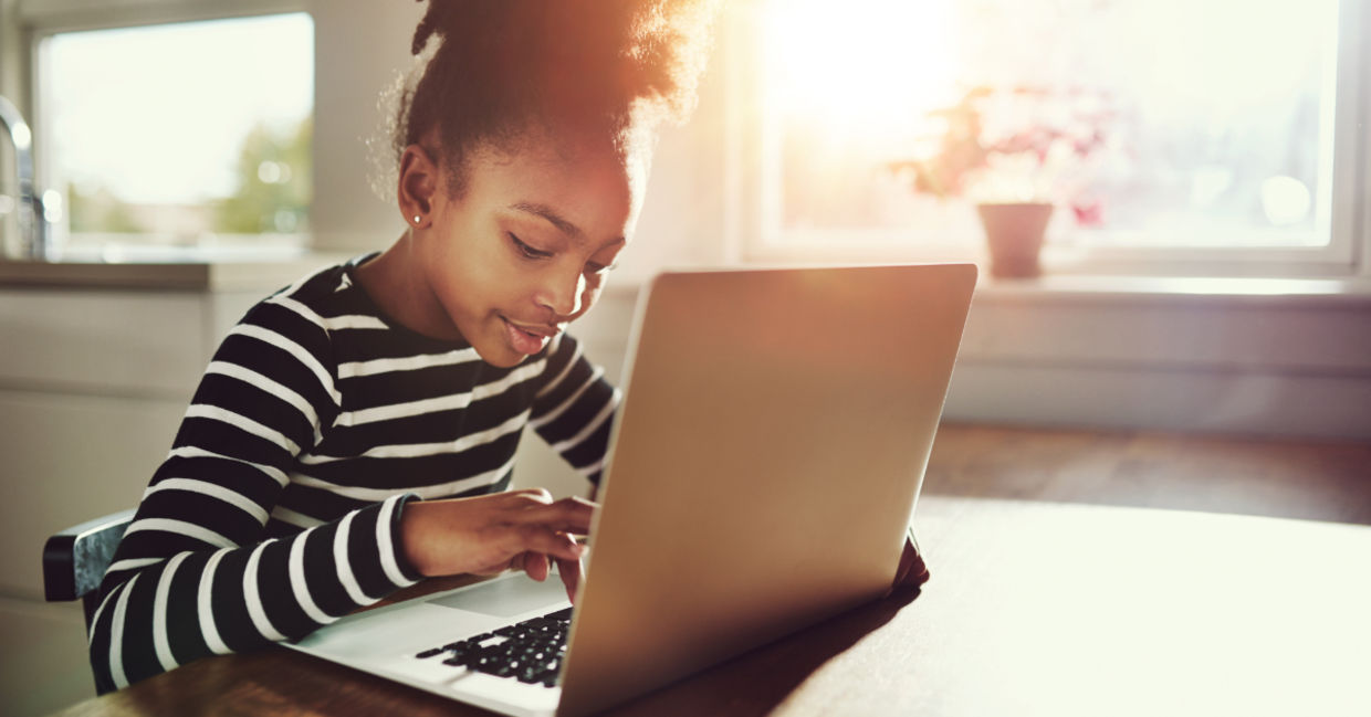A young girl using a laptop.