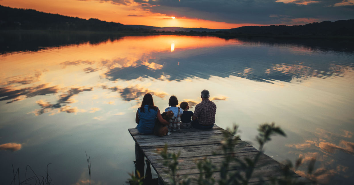 A family sitting on a bridge.