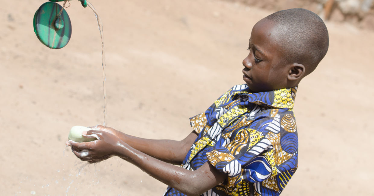 A boy washing his hands.