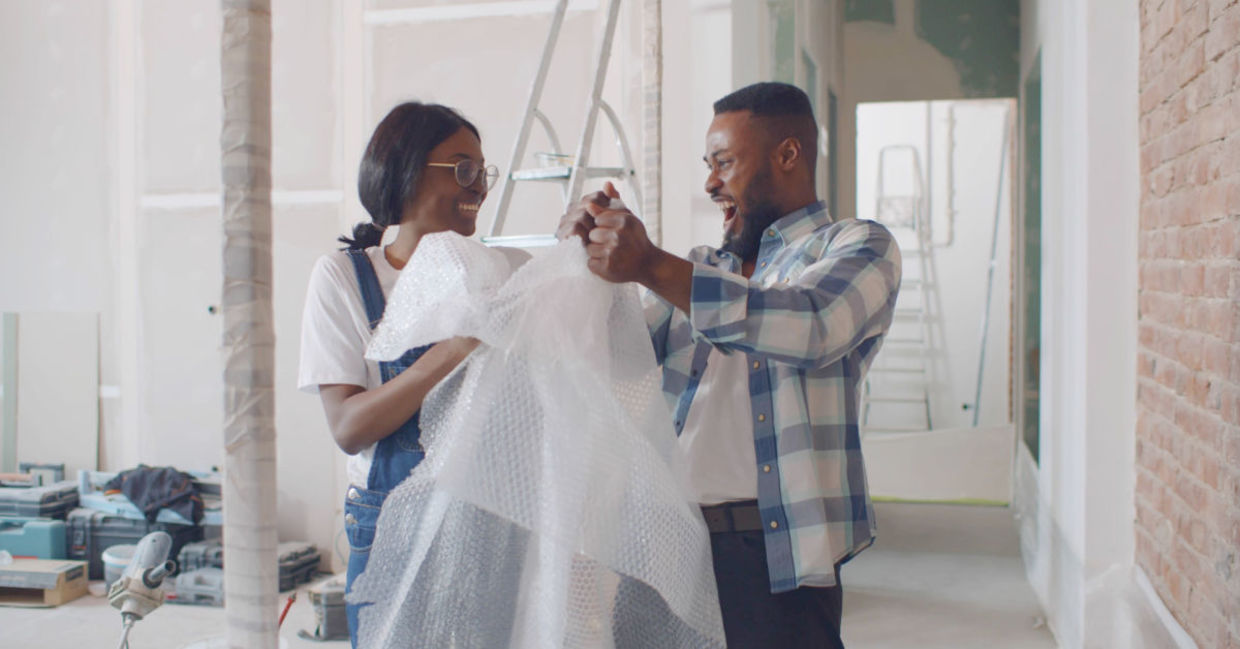 Happy couple having fun with bubble wrap.