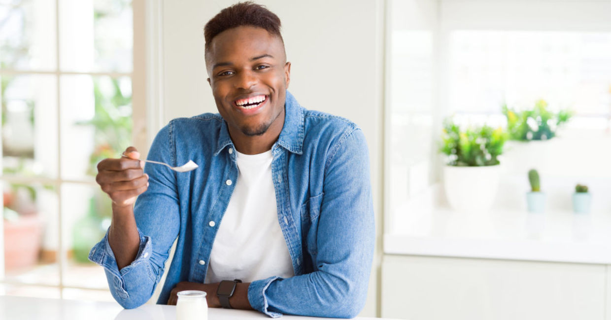 A man is eating sugar-free yogurt.