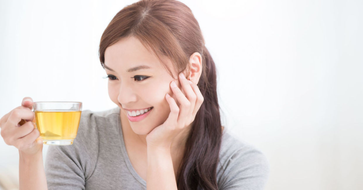 A woman sips green tea.