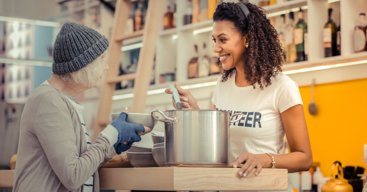 A volunteer giving soup to the homeless.