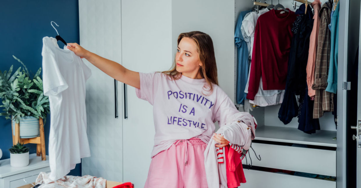Woman cleaning out unwanted clothing from her closet.