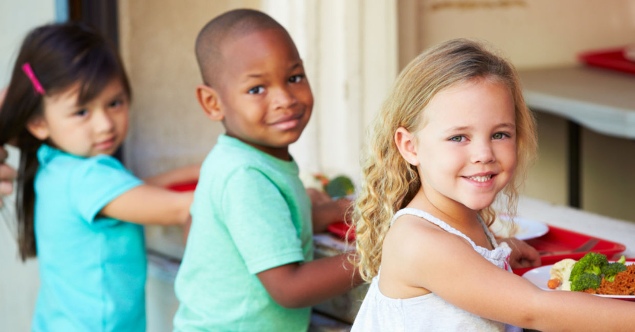 Elementary pupils collect healthy school lunches in the cafeteria.