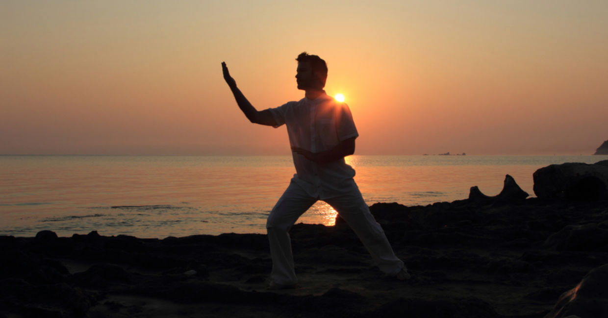 Man doing tai chi at sunrise.