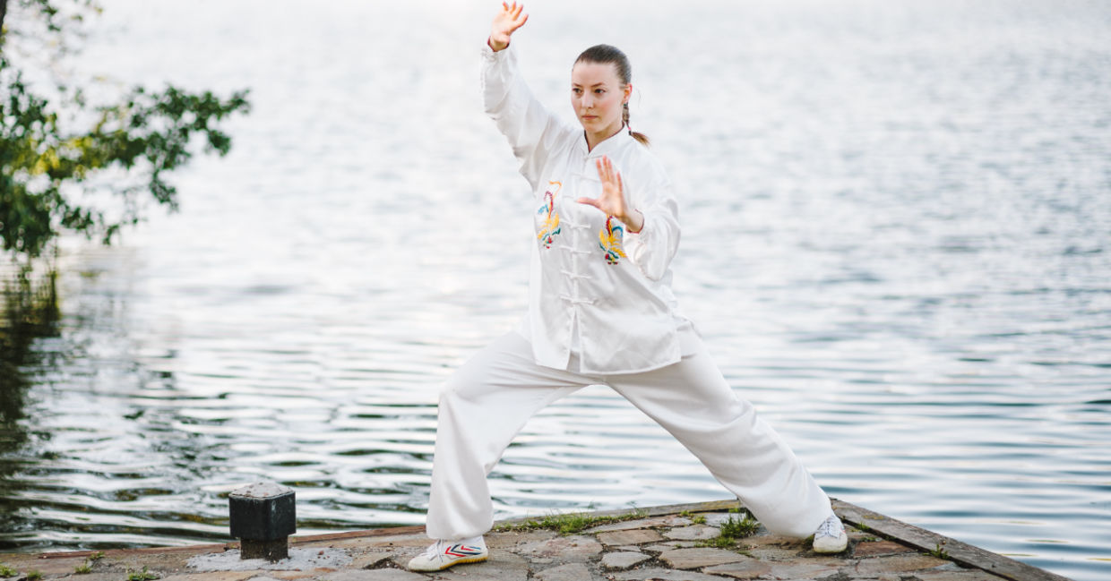 Tai chi in a garden with flowing water.