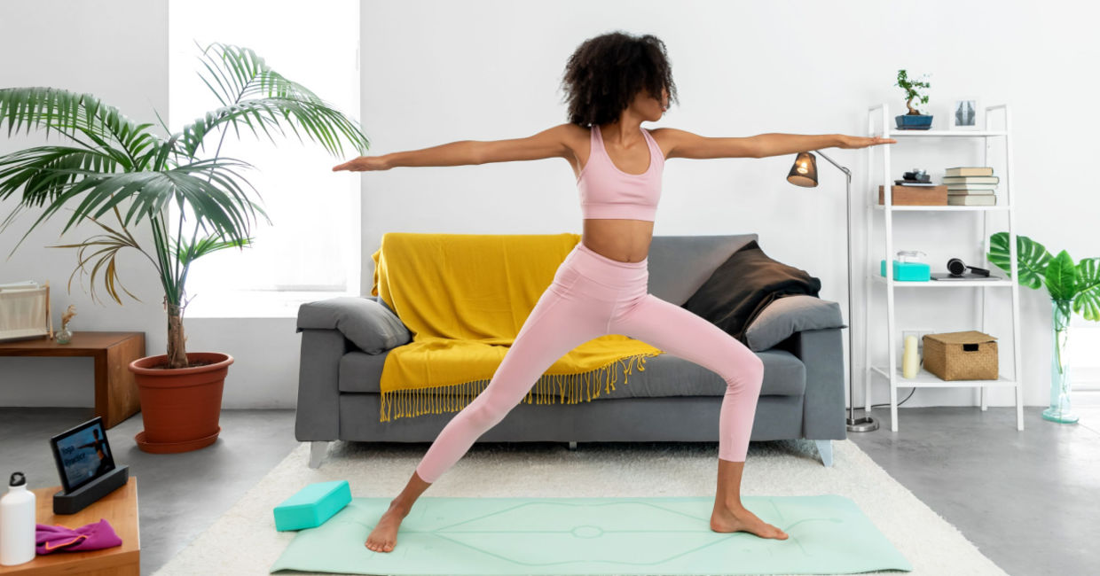 Woman standing tall in the Warrior II yoga pose.