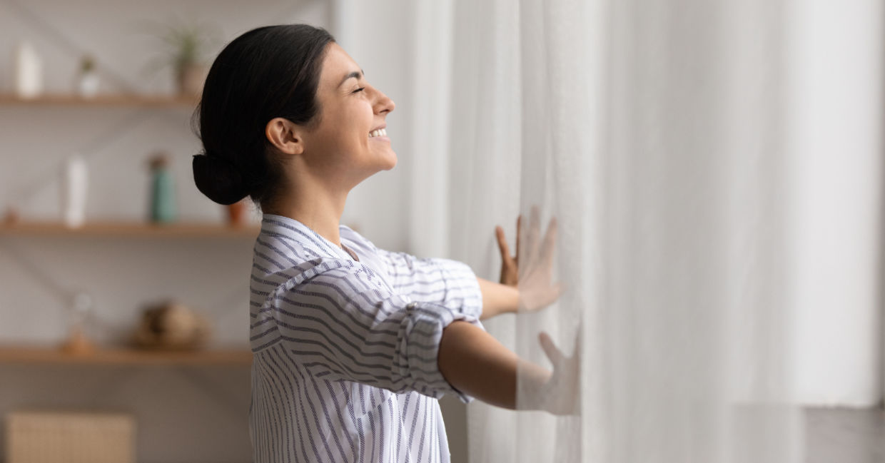 Opening drapes to let the sunlight in.