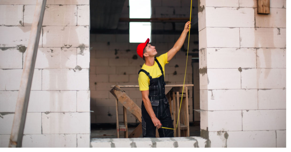 Construction worker using concrete blocks.