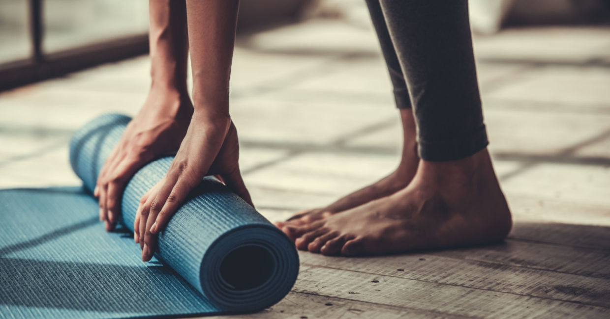 Man rolling out his yoga mat.