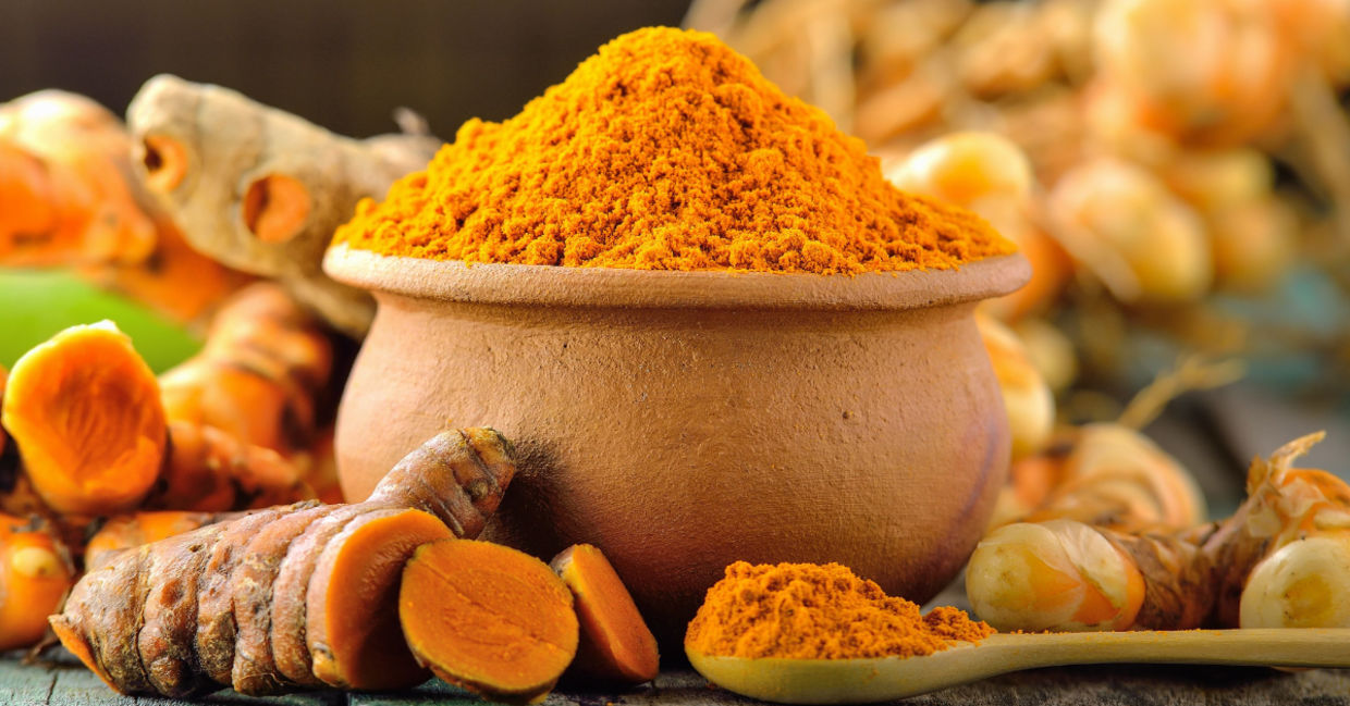 Healthy turmeric roots and ground spice.