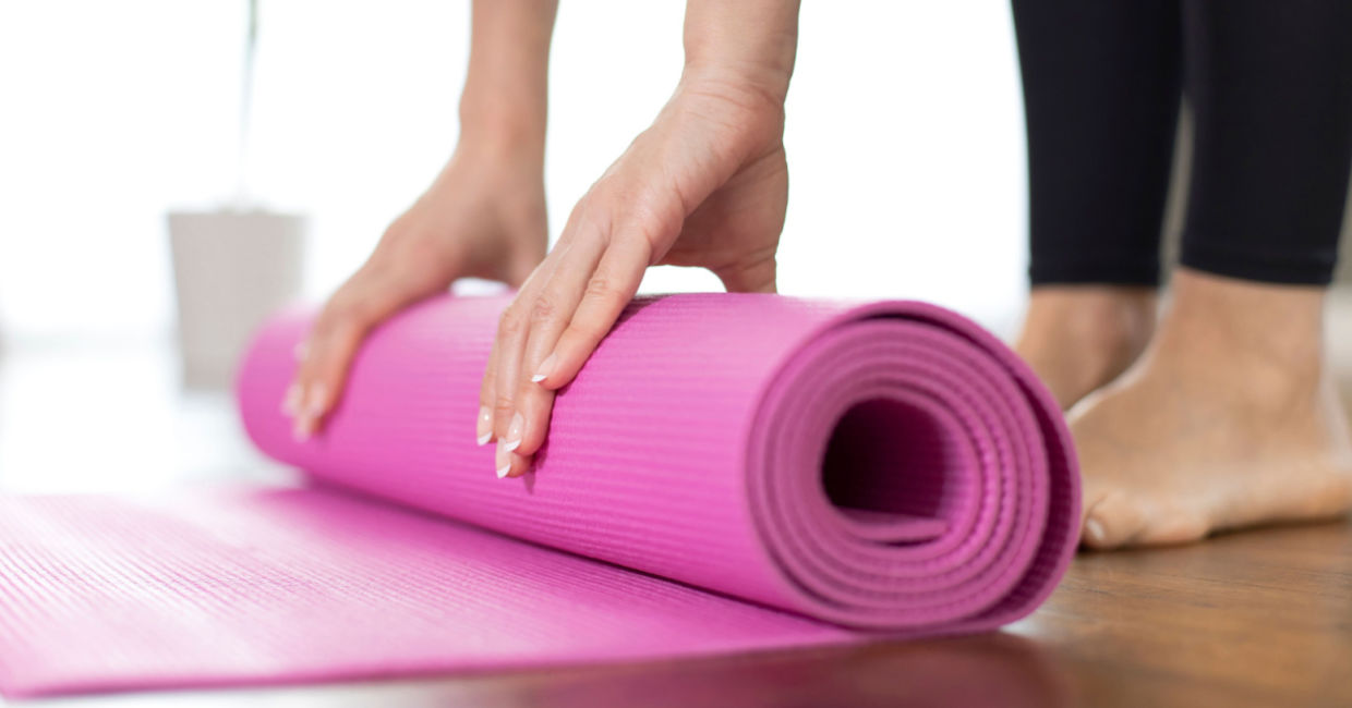 Woman unrolling her yoga mat.