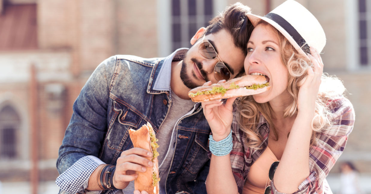 Couple enjoying a sandwich lunch outside.