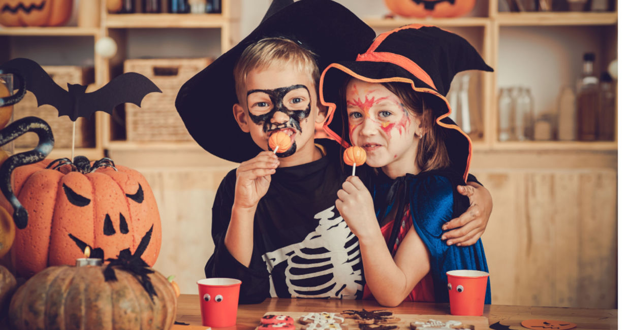 Costumed children enjoying festive foods.