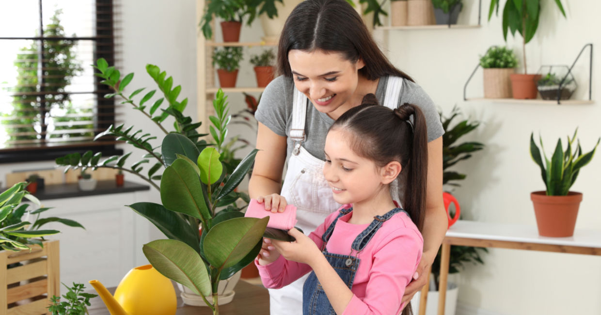 Mother and daughter taking care of houseplants.