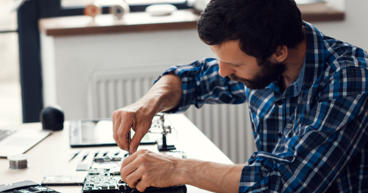 A man repairing a laptop computer.
