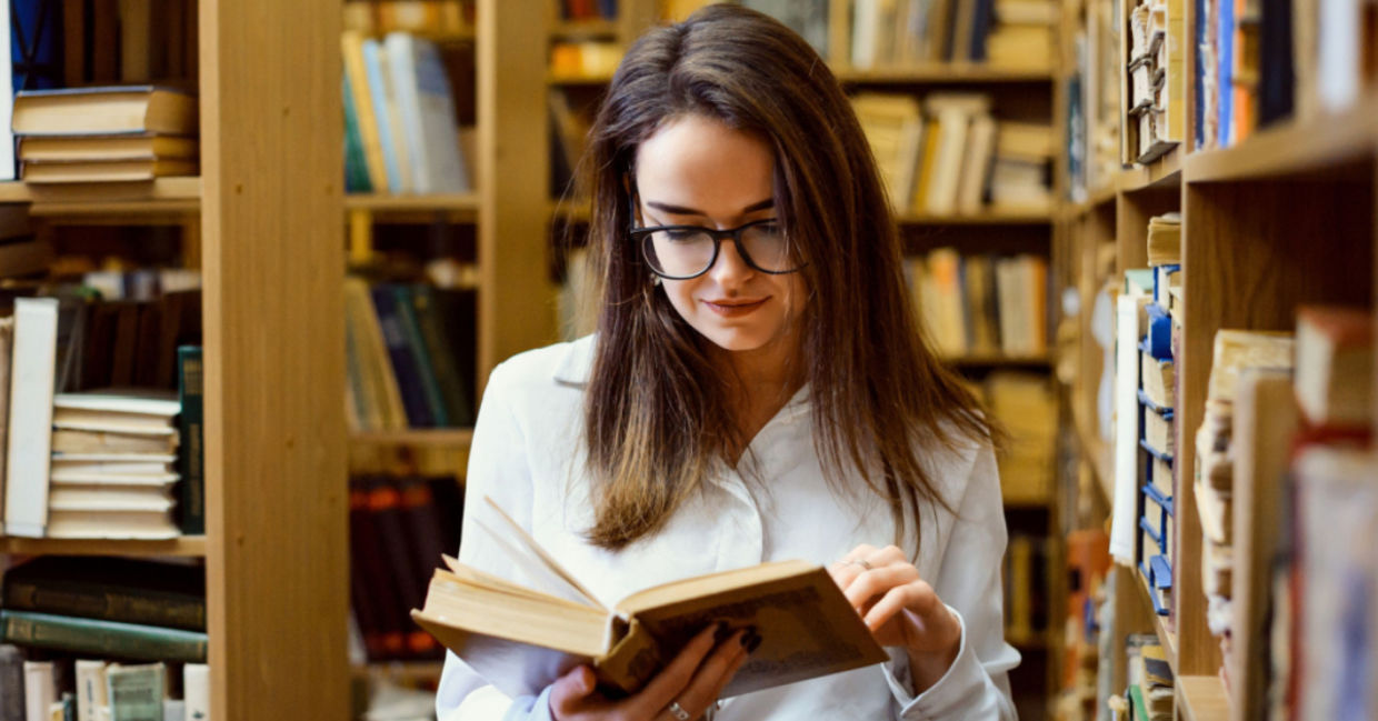 A woman looking words up in a dictionary.