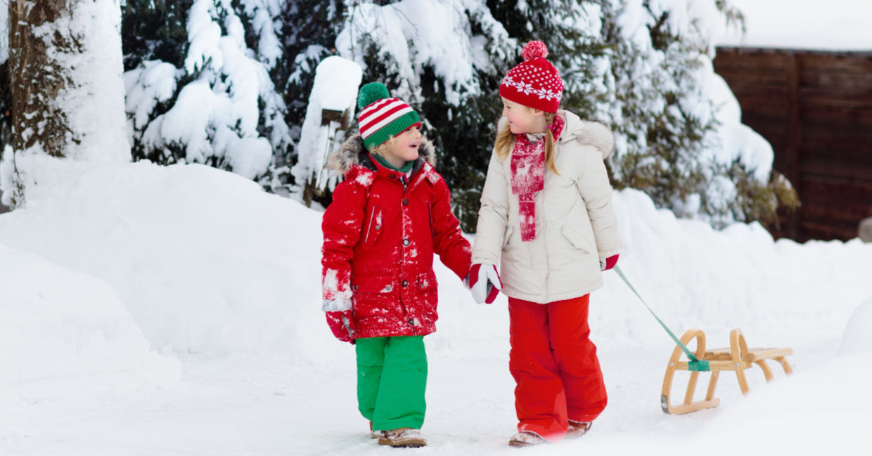 Child going sledding in the snow.