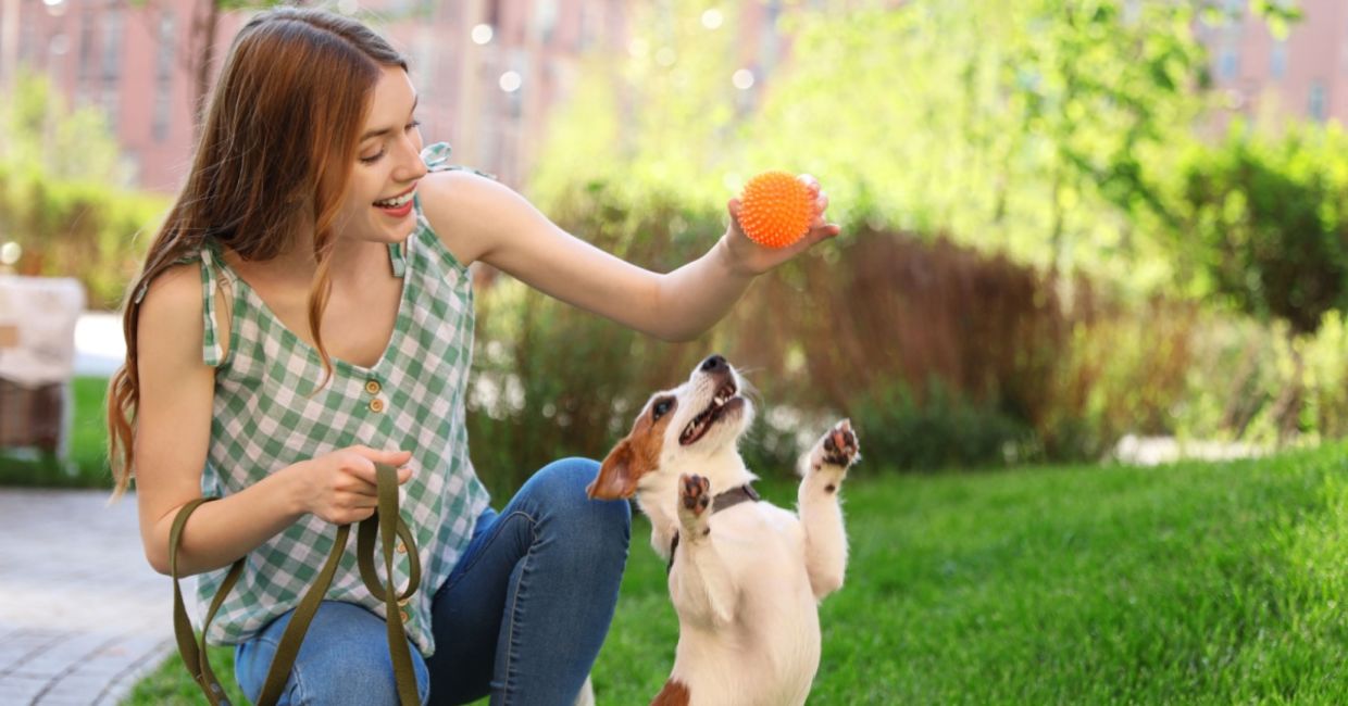 A woman playing with her dog.