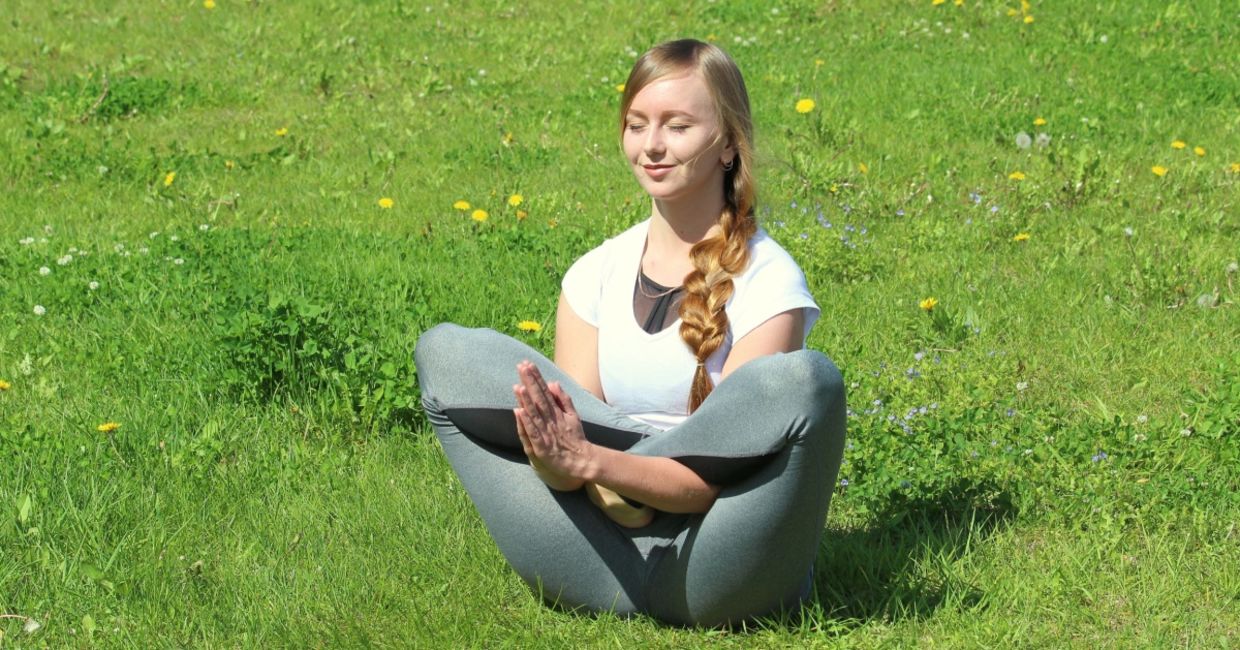 Woman practicing the flower yoga pose.
