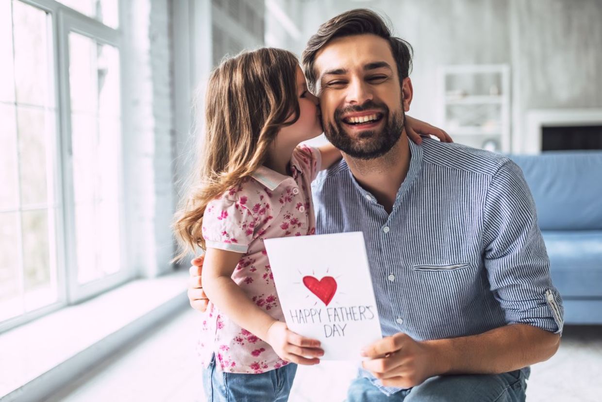 A daughter giving a card to her father,