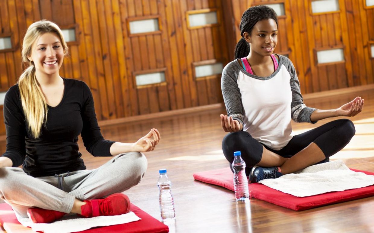 Teenage girls beginning a yoga session.