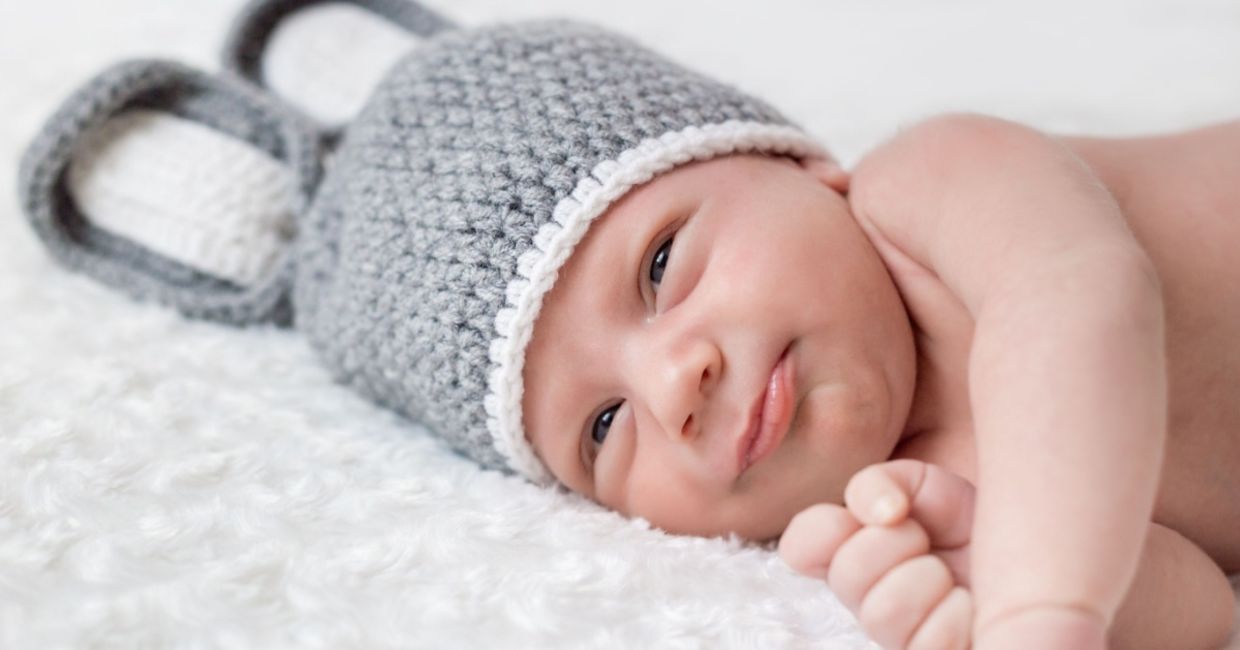 Cute newborn on a white blanket.