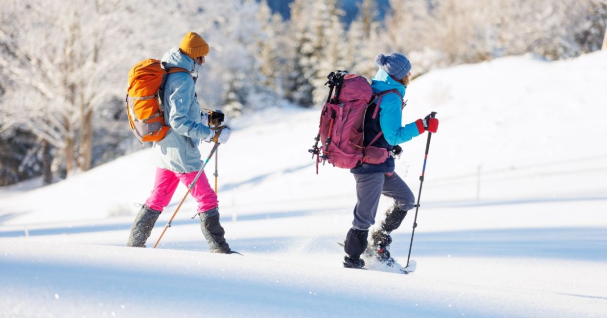 Two women winter hiking in snowshoes.