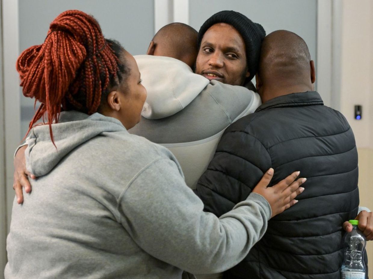 Avera Mengistu embraces his family.