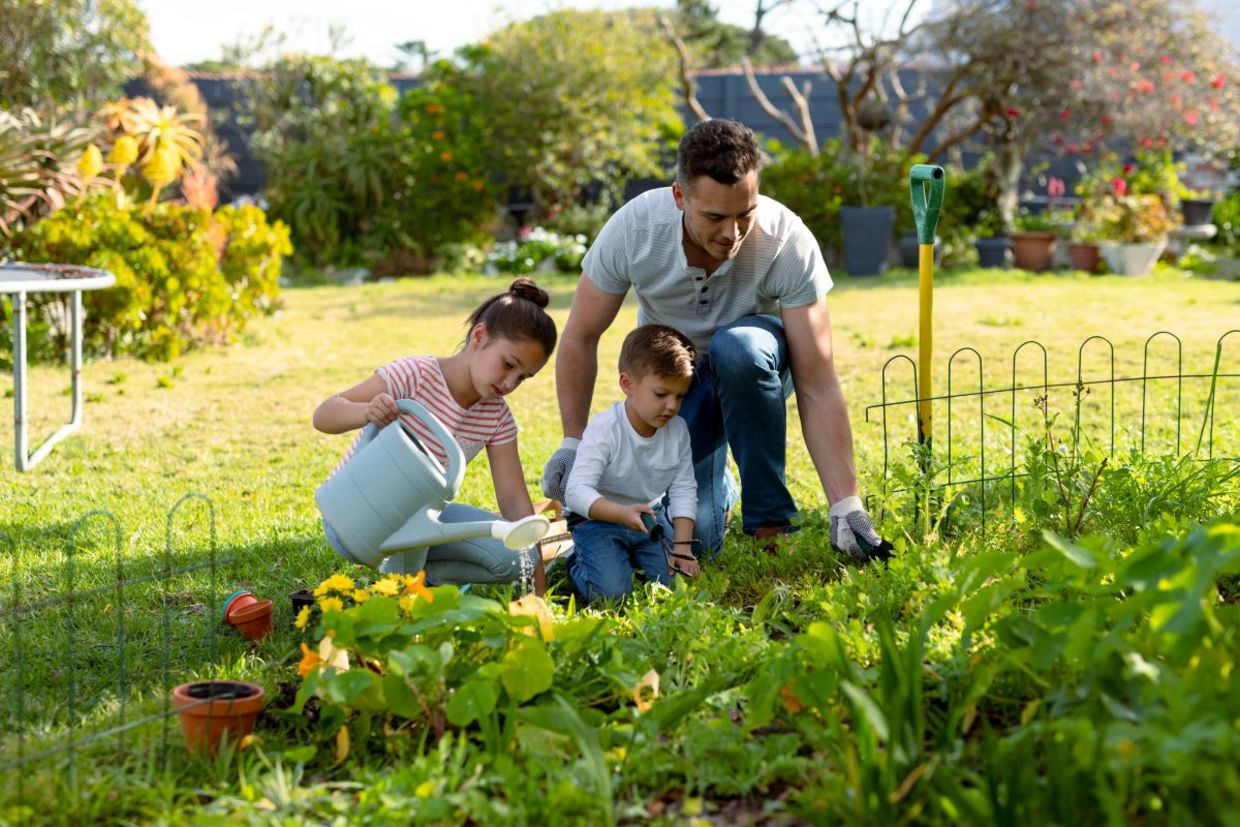 Kids help to weed a garden.