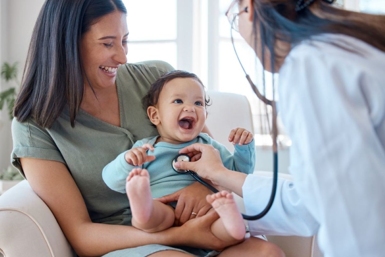 A baby smiles during a medical checkup.