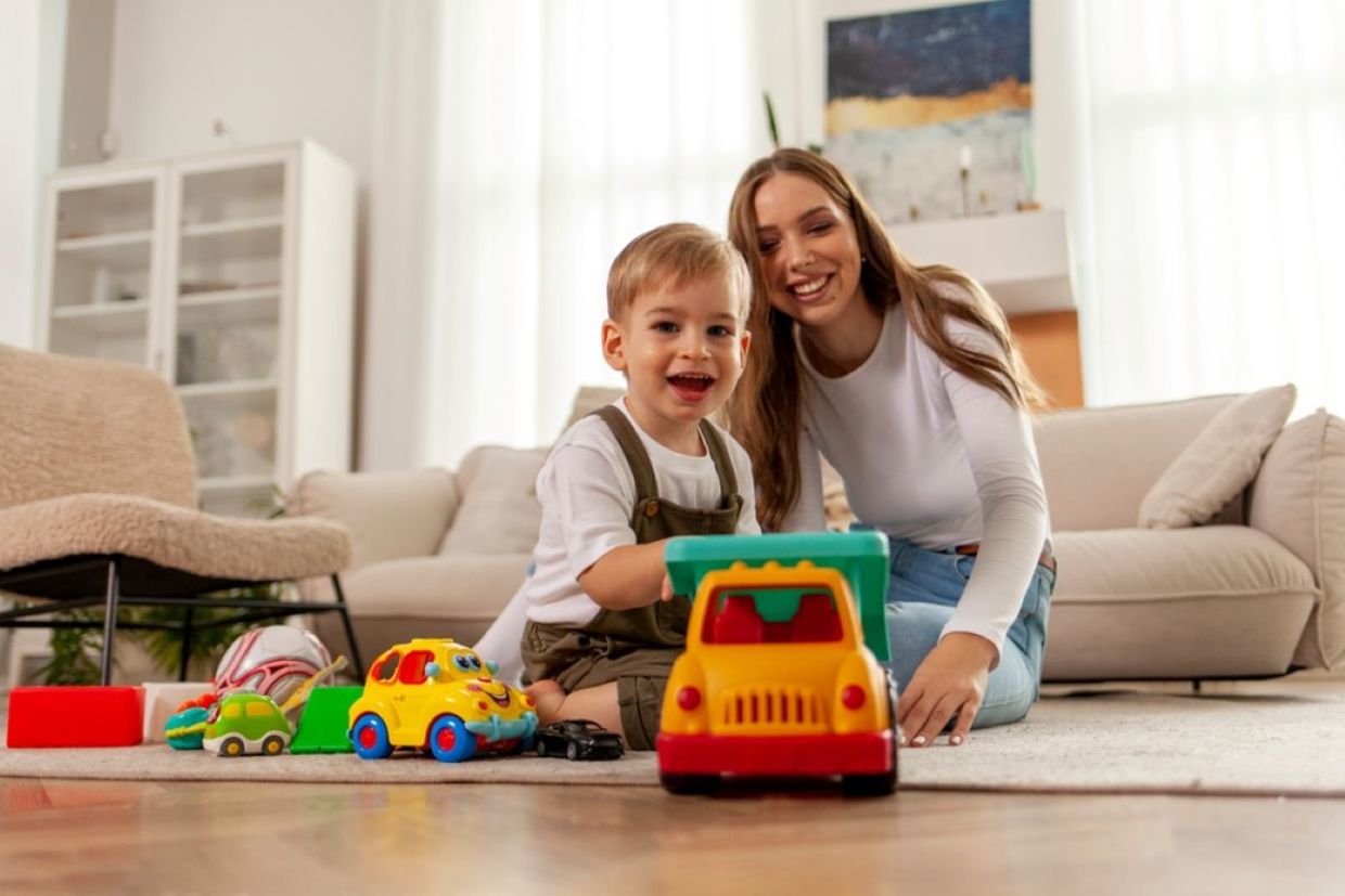 A kid plays with a toy car.