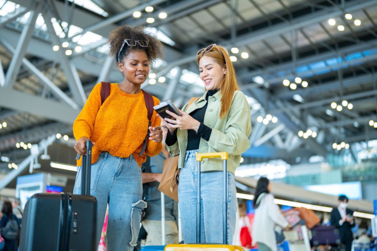 Two women stand in an airport.