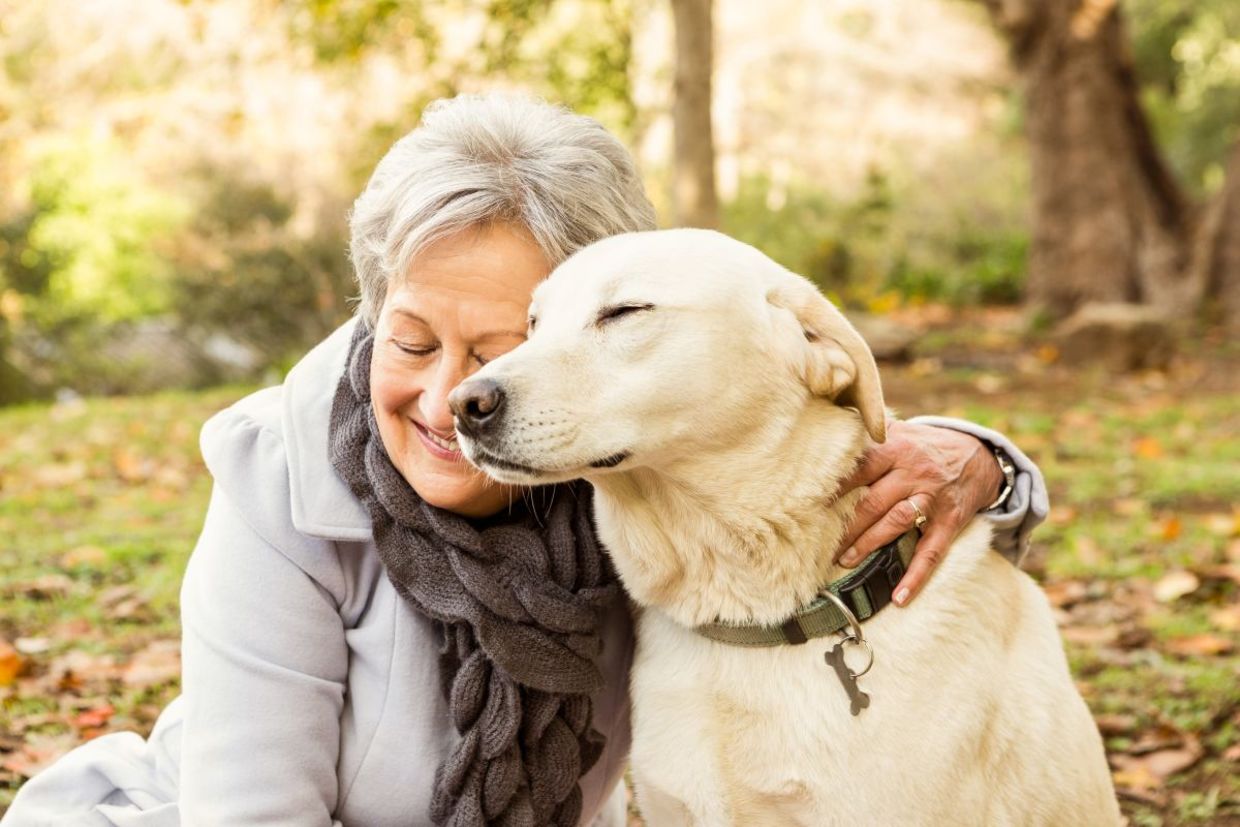 A senior woman cuddling with her dog.