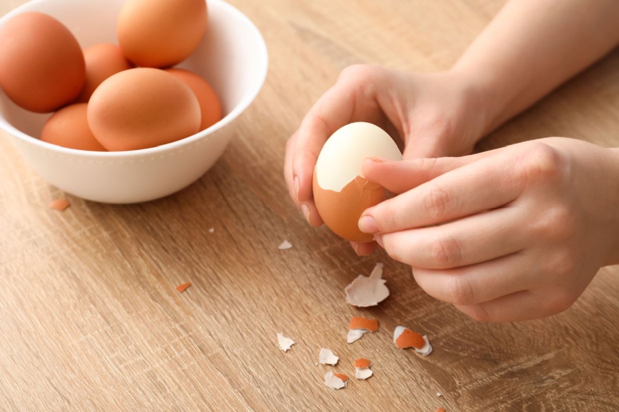 A person peels an egg.