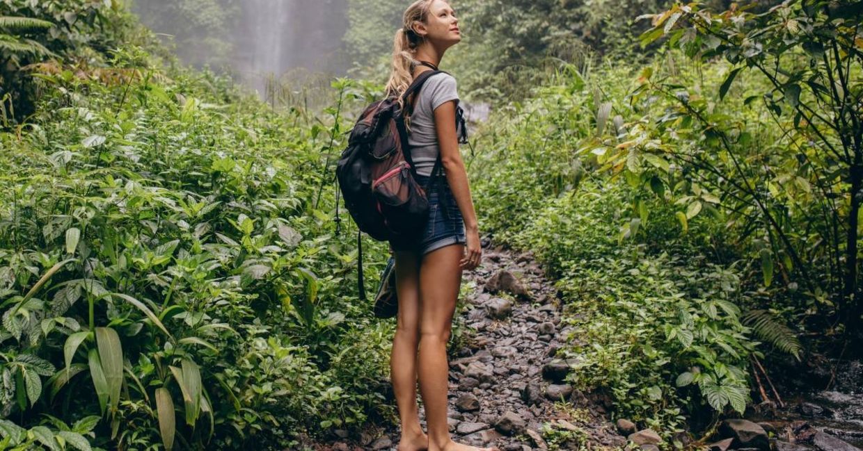 A woman walking barefoot in the forest.