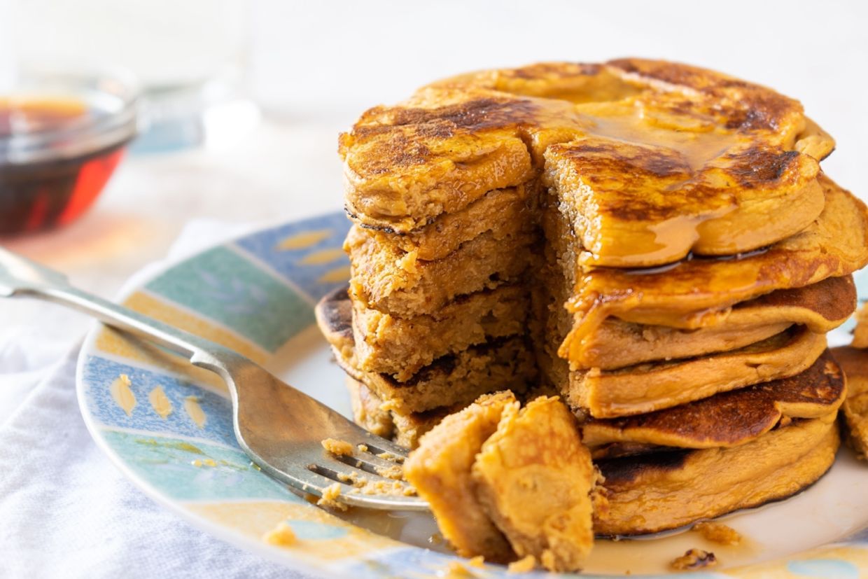 Sweet potato pancakes piled up on a plate.