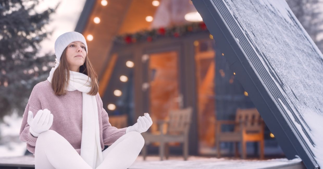 Woman meditating outside in winter.